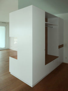 Wohnzimmer-Raumteiler, Rückseite Garderobe. Weiß lakiert in Kombination mit amerikanischem Kirschbaum.